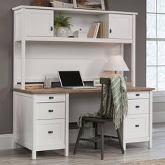 a white desk with a laptop on top of it and a lamp next to it