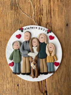 a family ornament on a wooden table with a small dog and two people