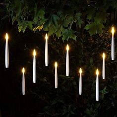 white candles are arranged in the shape of an eight - pointed figure on a dark background