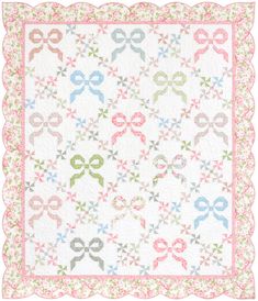 a white quilt with pink, blue and green bows on the border is displayed in front of a white background