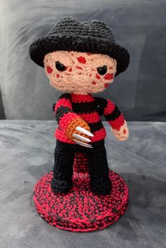 a crocheted doll holding a fork and knife