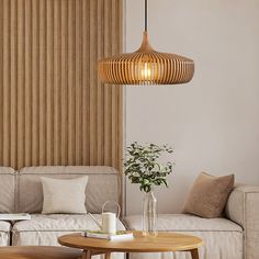 a living room filled with furniture and a wooden light fixture hanging over the top of a coffee table