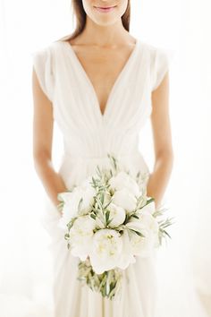 a woman in a white dress holding a bouquet