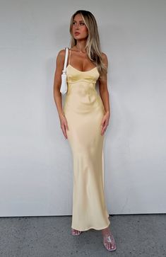 The perfect elegant moment with the It's Not The Same Maxi Dress in Lemon. Features a low cut neckline, thin adjustable straps, maxi length, self lined satin feel fabric, backless design, hidden side zipper with hook & eye, front bust cup design and adjustable hugging fit! Pair with gold accessories and a high shine bag for a party ready fit!  - 95% Polyester 5% Elastane- Em is 171cm & is wearing an XS Yellow Maxi Dress Wedding, Maxi Formal Dress Yellow, Elegant Birthday Dress Classy, Beach Guest Wedding Dress, Old Money Wedding Guest Dress, Feminine Yellow Fitted Maxi Dress, Wedding Guest Ideas Outfit, Light Yellow Satin Prom Dress, Yellow Bridesmaids Dress