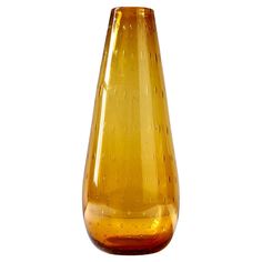 a yellow glass vase sitting on top of a table