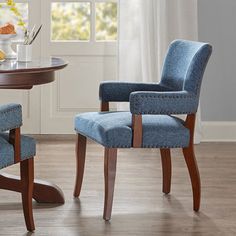 two blue chairs sitting in front of a table