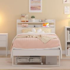 a white bed sitting in a bedroom next to a night stand and desk with drawers