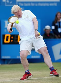 a man hitting a tennis ball with a racquet