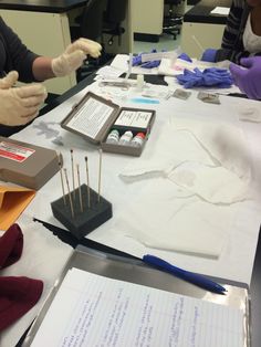 two women working on crafts at a table with paper and scissors in front of them