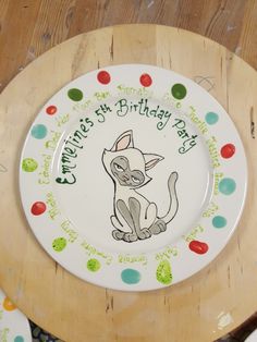 a white plate with a drawing of a cat on it and the words children's birthday day