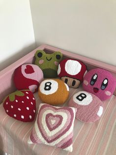 several stuffed animals sitting on top of a bed next to pillows and pillow cases in the shape of hearts