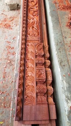 an intricately carved wooden bench sitting on the ground