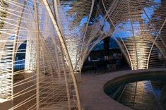 an artistic sculpture in front of a swimming pool at night with lights shining on it