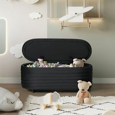 there is a toy chest in the room with teddy bears and other toys on the floor