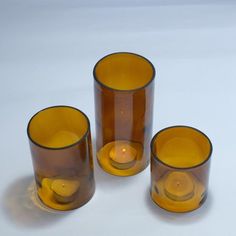 three brown glass candlesticks sitting next to each other on a white table top