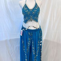 a woman's blue and white belly dance outfit with silver beads on the waist