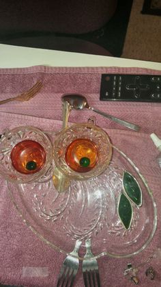 two glass dishes with spoons and forks on a pink towel