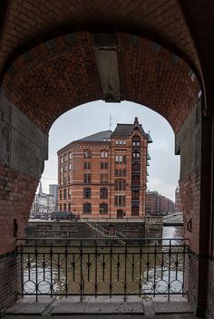 an archway leading to a building next to a body of water