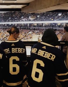 two women in hockey jerseys sitting at a bench