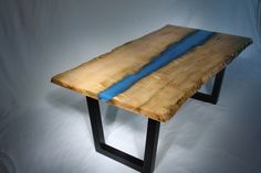 a piece of wood that is sitting on top of a metal stand with a blue strip