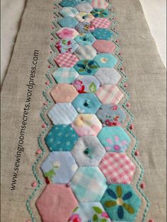 a table runner made out of patchwork and fabric with flowers on the border,