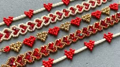 several red and white beaded bracelets are laying on the floor