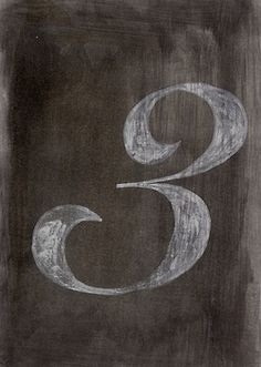 the number three drawn on a blackboard with white chalk