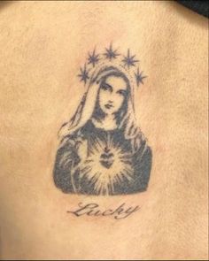 a woman's back with a tattoo on it that says lucky and the image of mary