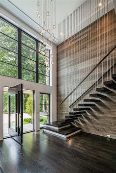 a large open floor plan with stairs and glass walls