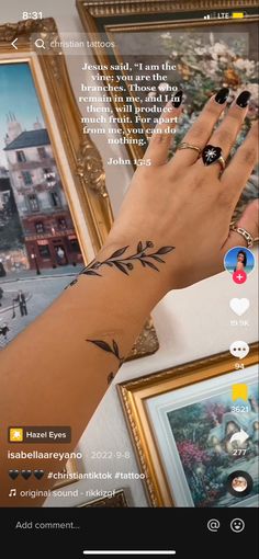 a woman's hand with a tattoo on her left arm next to two framed pictures