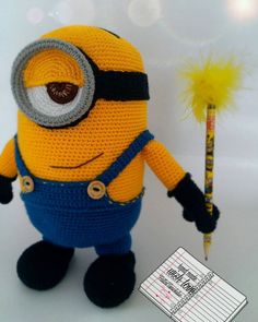 a crocheted minion holding a pencil