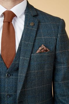 a man in a suit with a tie and pocket square on his lapel jacket