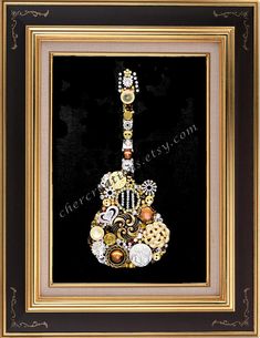 a guitar made out of buttons and other items in a gold frame on a black background