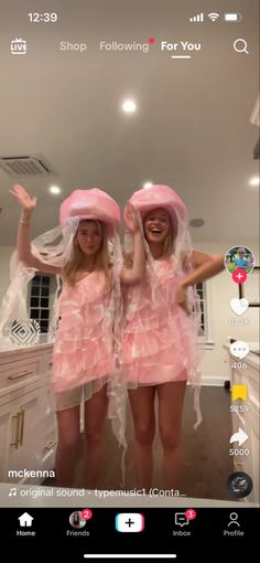 two women in pink dresses and hats standing next to each other