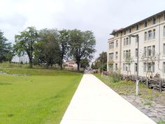 an empty sidewalk in front of a large building