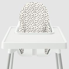 a white high chair with black dots on it