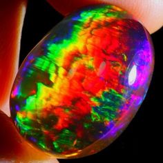 a person holding an opal in their hand