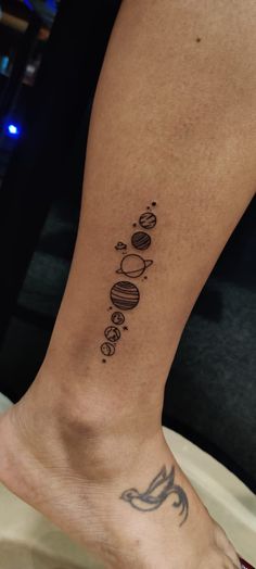 a person with a tattoo on their foot that has the planets and stars in it