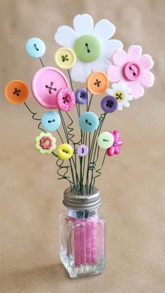 a vase filled with lots of different colored buttons