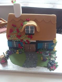 a cake shaped like a house with flowers on it