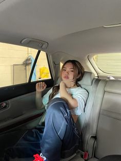 a woman sitting in the back seat of a car