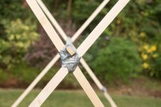 a piece of wood is tied to the side of a wooden pole with two pieces of tape on it