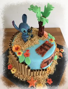 a birthday cake decorated with an image of a blue bird and palm tree on top