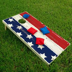 an american flag themed cornhole game on the grass with red, white and blue pieces