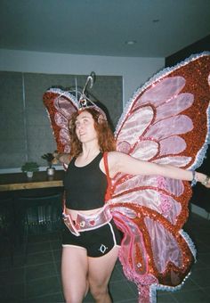 a woman in a butterfly costume poses for the camera