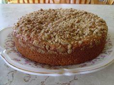 a cake sitting on top of a white plate covered in crumbly toppings