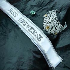 a white sash with the words mss university on it next to a brooch