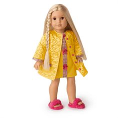 a doll with blonde hair wearing a yellow coat and pink slippers, standing in front of a white background