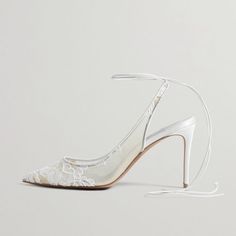 a pair of white high heeled shoes with lace