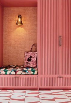 a bedroom with pink walls and patterned flooring in the room is lit by a lamp